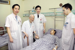 邓铁涛(左二)在给冠脉支架术后患者把脉