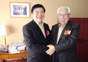 陈竺(左)与李辅仁(右)亲切握手。